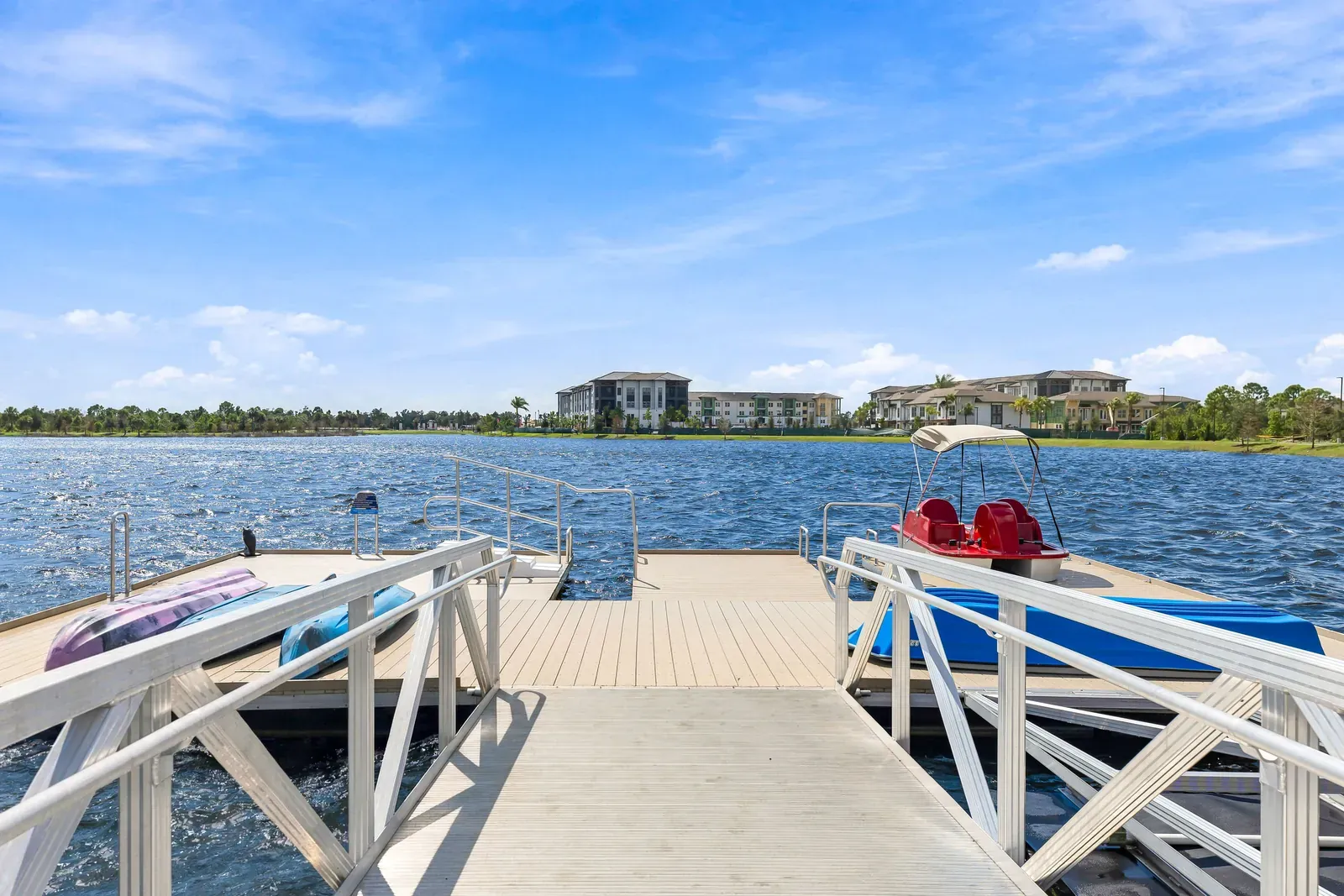 Floating dock on the lake with kayaks and a pedal boat tied up in Wellen Park