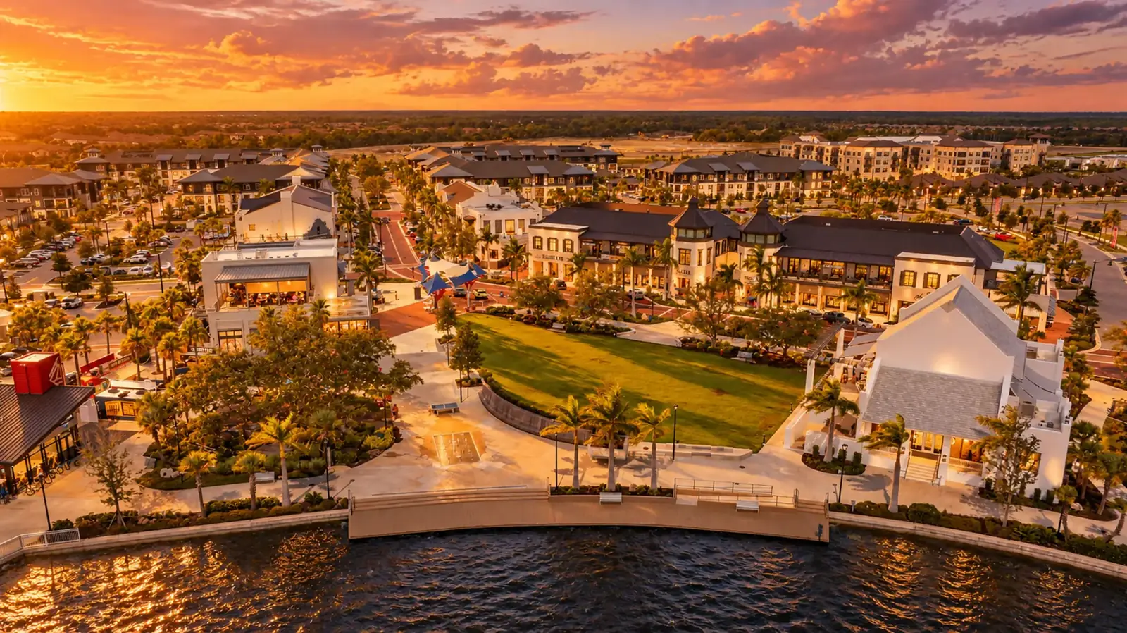 Aerial view at sunset over the lake, lawn and rooftops of Downtown Wellen Park